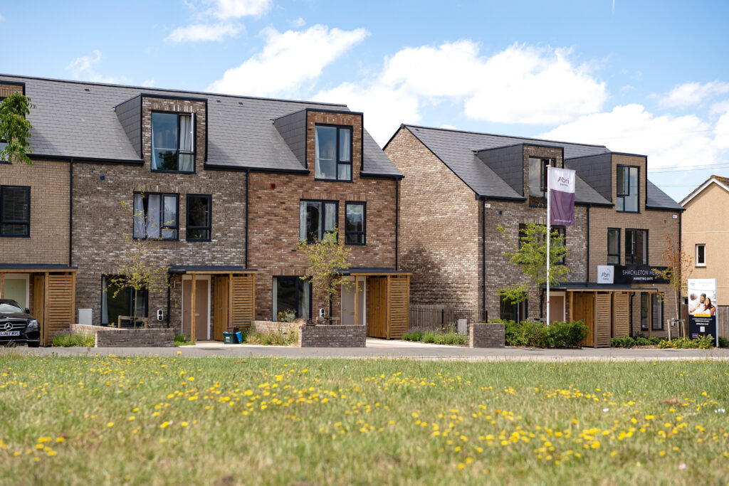 Shackleton Heights, Lockleaze in Bristol. A housing development by Abri. Main contractor Speller Metcalfe. Image shows outside of three storey semi-detached and terraced houses built in brick with dormer windows and timber entrance porches